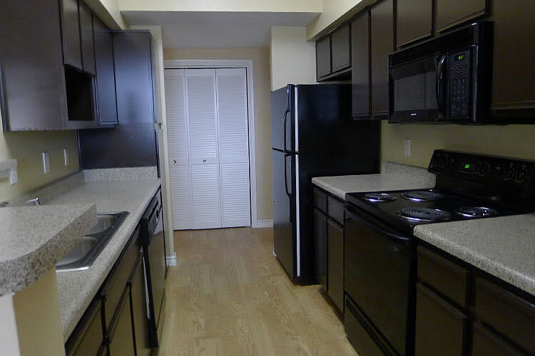 The Lodge at West Oaks apartment kitchen with dark cabinetry